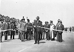 Ribbon ceremony to open the Sydney Harbour Bridge on 19 March 1932. Premier Lang cuts the ribbon while Game looks on.