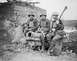 Four men of the 4th (Pioneer) Battalion, Coldstream Guards perched on a wrecked gun outside a German concrete blockhouse on the outskirts of Houthulst Forest, Belgium, 9 October 1917.