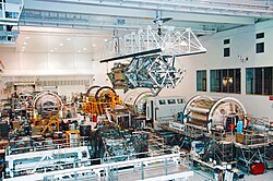 S3-S4 Truss being hoist to the payload transfer container inside the Space Station Processing Facility next to several other ISS modules (2007)