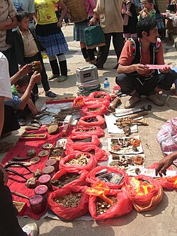 A vendor selling illegal items at a Chinese market for use in traditional Chinese medicine. Some of the pieces pictured include parts of animals such as a tiger's paw.