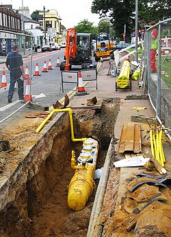 Polyethylene plastic main being placed in a trench