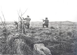 Julius Popper (on left) shooting, with a Selkʼnam corpse visible in the foreground