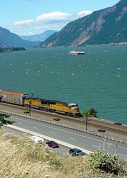 Cars, a train, and a boat traveling