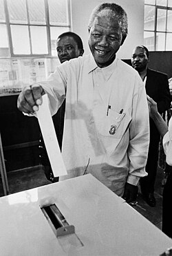 Nelson Mandela voting in the 1994 multi-racial elections in South Africa. It was the first time he had voted in his life.[139][140]