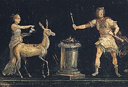 An ancient Fourth-Pompeian-Style Roman wall painting depicting a scene of sacrifice in honor of the goddess Diana; she is seen here accompanied by a deer. The fresco was discovered in the triclinium of House of the Vettii in Pompeii, Italy.