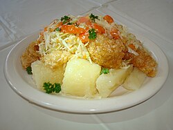 Vigorón, a Nicaraguan dish served with boiled yuca and chicharrones (fried pork with skin) and topped with a cabbage salad