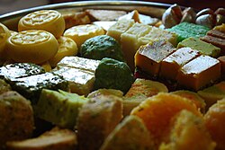 A tray of South Asian sweets, with some pieces covered with shiny silver vark