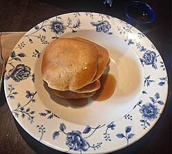A stack of American style pancakes, served with maple syrup