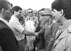 Bachir Gemayel, commander-in-chief of the Lebanese Christian Forces, shaking hands with Rafael Eitan, Israeli chief of staff, in front of Avner Azoulay, representative of the Mossad (center), on June 1, 1982, five days before the Israeli invasion of Lebanon.