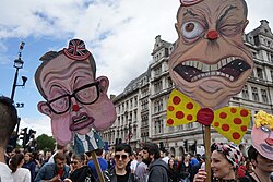 Crowd holding caricature placards of two politicians during a protest