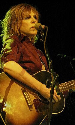 Singer Lucinda Williams strumming a guitar