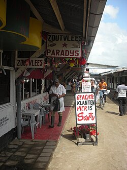 Butcher in the Central Market in Paramaribo with signs written in Dutch