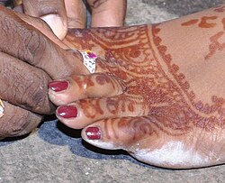 A woman's toes decorated with nail polish and henna, and wearing a metti (toe ring) on the second toe, for her wedding