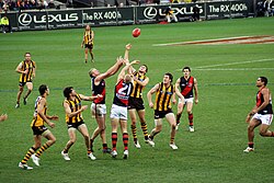 An AFL match between Hawthorn and Essendon in 2007. The home team, Hawthorn, is wearing dark shorts, with the away team, Essendon, wearing white shorts