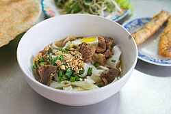A bowl of mì Quảng with pork and egg.