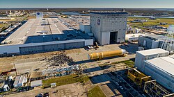 The Michoud main manufacturing building and the twin vertical assembly buildings as seen from a drone in January 2020. The Artemis I core stage is being rolled out, along with a crowd of workers