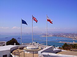 The Union Jack in a raised, central position, flanked by the Flag of Europe (left) and Flag of Gibraltar