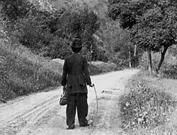 Charlie Chaplin (1915) walking down the road dejectedly, in the famous last scene of The Tramp, filmed on location in Niles Canyon, California