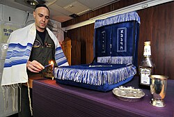US serviceman lighting a Menorah in observance of the first day of Hanukkah