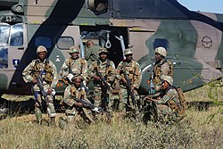 South African soldiers posing in front of a SAAF helicopter during 2013