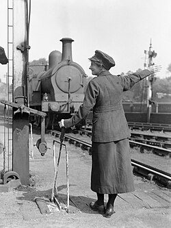 A railway worker operating a manual switch at a rail yard in Britain during World War I