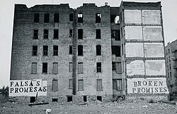 Urban decay in the US: the South Bronx, New York City, was exemplar of the federal and local government's abandonment of the cities in the 1970s and 1980s; the Spanish sign reads "FALSAS PROMESAS", the English sign reads "BROKEN PROMISES".