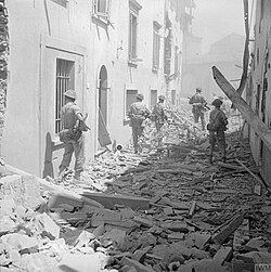 British infantry moving cautiously through the ruined streets of Impruneta, 3 August 1944