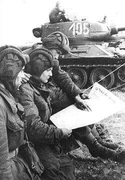 Soldiers in an East German tank unit reading about the erection of the Berlin Wall in 1961 in Neues Deutschland