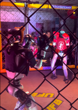 Humanoid robots in a staged boxing match during a robotics exhibition.