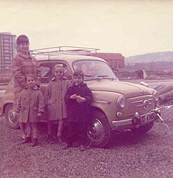 A mother with her three children stands next to her SEAT 600 in San Sebastián, in the mid-1960s. The SEAT 600 became a symbol of Spain's emerging mass consumer society.