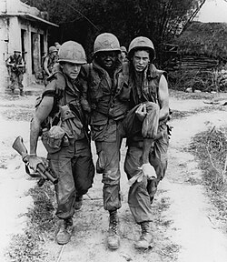 A wounded Black American soldier being evacuated during the My Lai Massacre