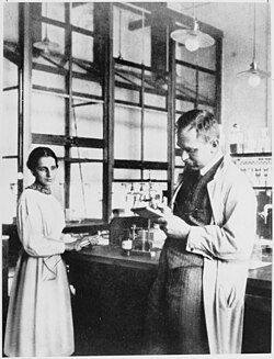 Hahn and Meitner, 1913, in the chemical laboratory of the Kaiser Wilhelm Institute for Chemistry. When a colleague she did not recognise said that they had met before, Meitner replied: "You probably mistake me for Professor Hahn."[13]
