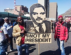 Two EFF supporters carry a placard depicting Atul Gupta at a Zuma Must Fall protest in Cape Town, April 2017.