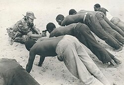 Rhodesian soldier interrogating villagers in late 1977 at gunpoint. This photograph would become one of the most enduring images of the Bush War.