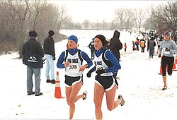 A cross country race taking place at a snowy park in the United States