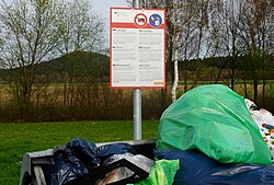 A multi-language sign in Germany telling people to dispose of waste food in closed waste bins to prevent boars eating it