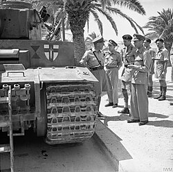 The badge of the First Army painted on a captured Tiger tank, being inspected by King George VI Tunis, June 1943.