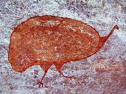 A rock painting of an animal in red paint
