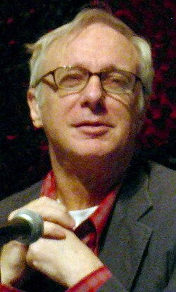 Robert Christgau, pictured in 2005, became one of the first professional rock and pop critics. He later criticised Rolling Stone for promoting the "boring rock-as-idealism myth".[2]
