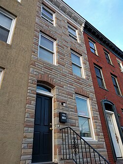 An Italianate rowhouse clad in formstone in West Baltimore