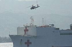 Helicopters transfer injured earthquake victims to hospital ship USNS Comfort off the coast of Haiti.