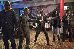 The Defenders and Stick from the 2017 miniseries (L-R: Mike Colter as Luke Cage, Scott Glenn as Stick, Finn Jones as Iron Fist, Krysten Ritter as Jessica Jones, Charlie Cox as Daredevil).