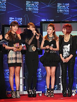 The group onstage, striking individual poses