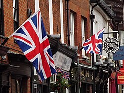 Union Jacks on two flagpoles hanging from a building in Surrey, 2012