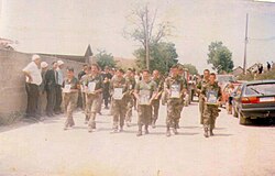 Kosovar Albanian soldiers holding pictures in memory of the men who were killed or went missing in the Krusha massacres