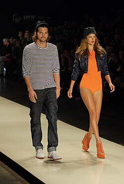 Ambrosio walking the runway with Ashton Kutcher at São Paulo Fashion Week in 2011