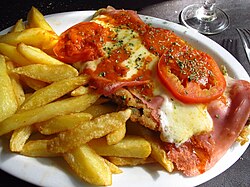 Milanesa a la napolitana with French fries, an Italian-inspired dish based on the original cotoletta alla milanese from Milan, Italy, common in South America