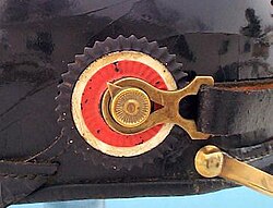 A metal cockade on the swivel of a Pickelhaube helmet.