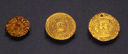 Crusader coins of the Kingdom of Jerusalem. Left: Denier in European style with Holy Sepulchre (1162–75). Center: Kufic gold bezant (1140–80). Right: gold bezant with Christian symbol (1250s). Gold coins were first copied dinars and bore Kufic script, but after 1250 Christian symbols were added following Papal complaints (British Museum).
