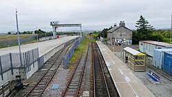 The platform and freight terminal at Georgemas Junction station, looking west towards Inverness; the branch to Thurso can be seen diverging off the main line to the right immediately beyond the platform.